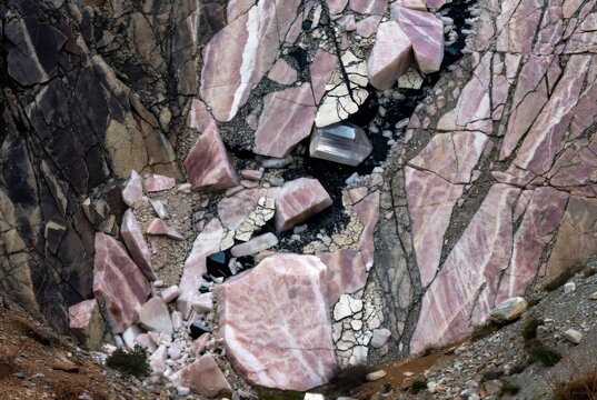 Rhodonite with pieces of diamonds. A close-up of the rhodonite mineral with pieces of diamonds. Natural stone texture with pink and gray shades.