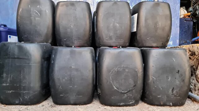 Sidoarjo, Indonesia - 8 June, 2026: Industrial Black HDPE Chemical Jerrycans Stacked in a Warehouse Facility