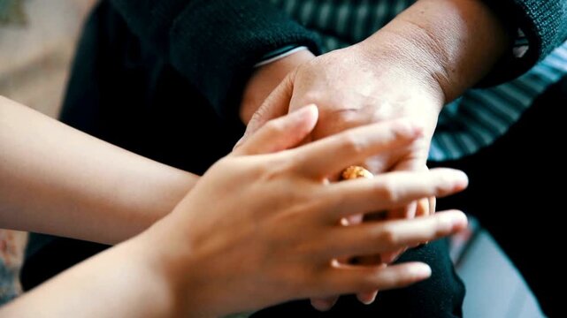 Close Up of Young Caregiver Holding Hands of Elderly Grandmother