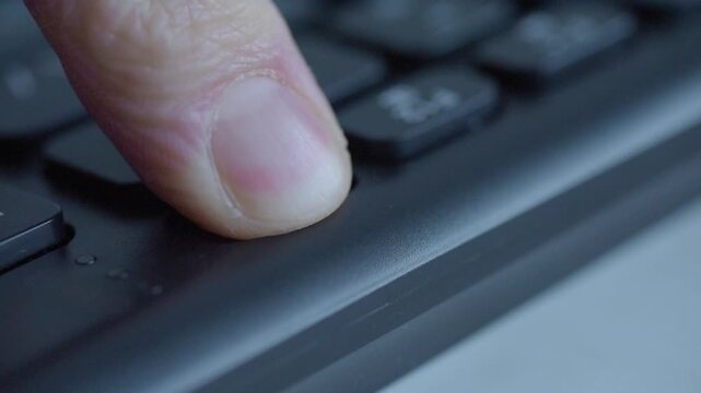 Closeup finger pressing delete key, office worker fingertip pushes keyboard key, slight camera blur as focus shifts away, suggestion of accidental file removal, tense mood