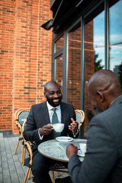 Two businessmen meeting over coffee at outdoor cafe