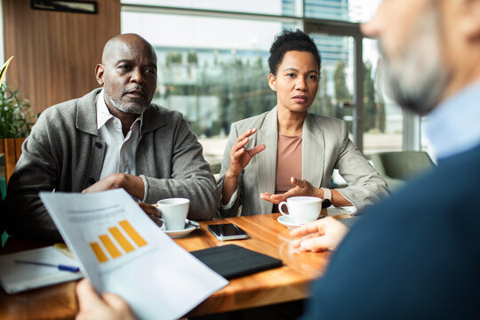 Couple meeting financial advisor at cafe