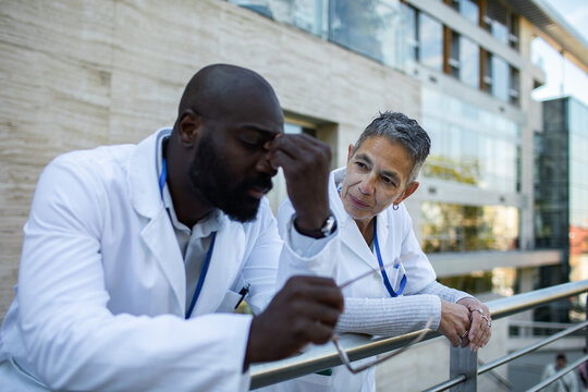 Concerned doctors discussing stress outside hospital