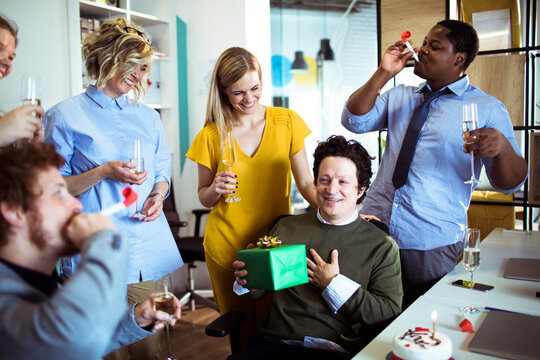 Coworkers celebrating a birthday in modern office