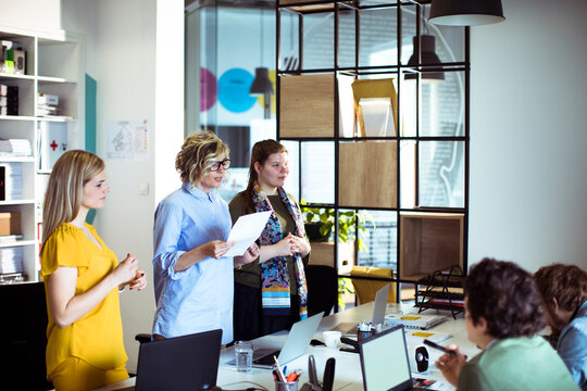 Female colleagues leading a team presentation in modern office