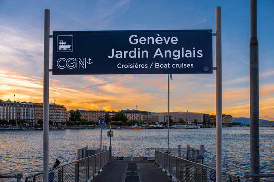 Geneva, Switzerland - June 3, 2026: CGN - Pier sign for Geneve Jardin Anglais boat cruises at sunset over Lake Geneva, with calm water, Geneva city buildings and an evening sky.