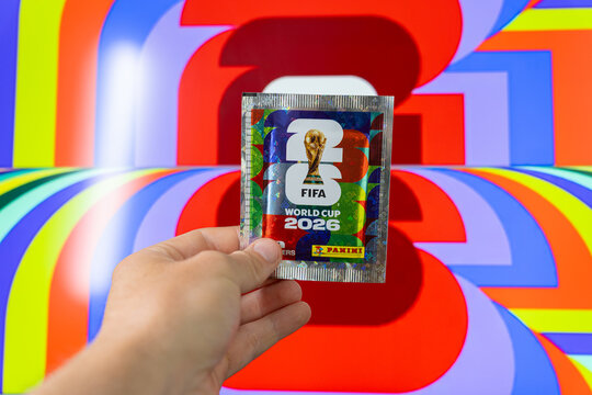 Hand holding Panini FIFA World Cup 2026 trading card sticker packs, foil booster packets for football soccer tournament collectors