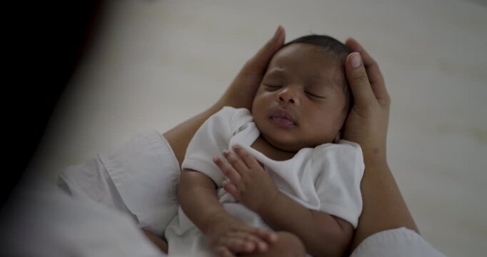 Close-up of newborn black African American baby mother gently supported during medical checkup, head  face message neonatal care, infant health, and professional healthcare.