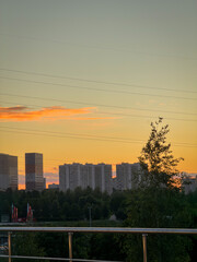 Naklejka premium Sunset view over buildings with a bright sky and trees in the foreground