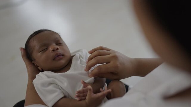 Medical professional gently h examining newborn baby, neonatal care, pediatric healthcare, infant wellness, and early development. African American mother message baby, hand pad head