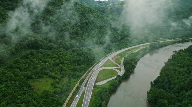 Aerial view of river canyon with road and low clouds