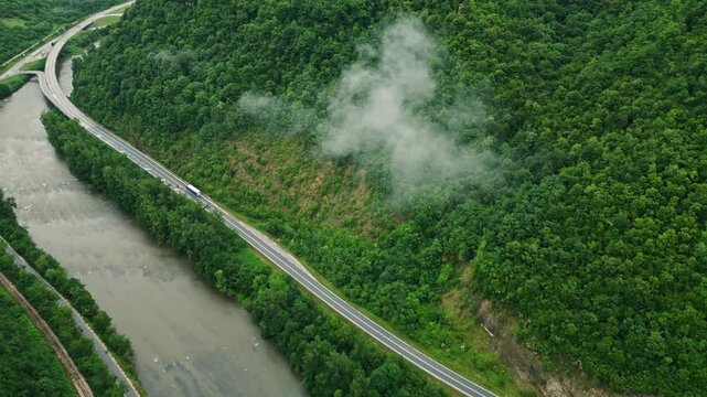 Aerial view of river canyon with road and low clouds