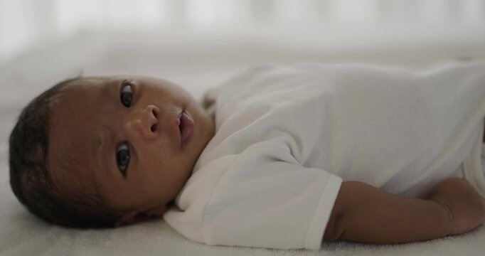 Adorable newborn baby resting on a soft white bed, capturing innocence, early childhood, newborn care, and family life.