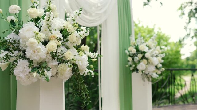 wedding arch of white rose flowers on the river bank before the wedding ceremony of the bride and groom, festive romantic decor	