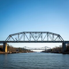 Fototapeta premium Calm canal with two steel truss bridges under clear blue sky