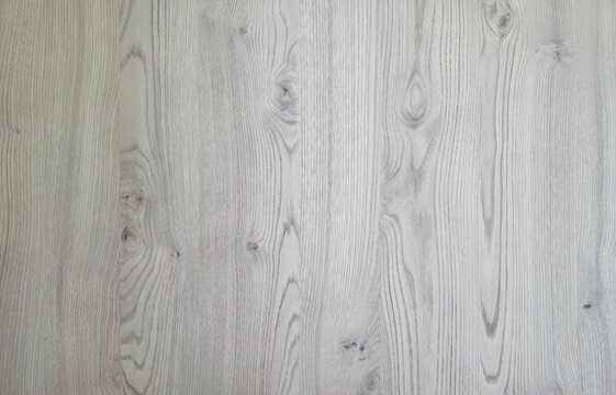 Light grey wood texture background with natural grain patterns and knots for interior design.