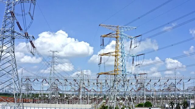 High Voltage Electrical Substation and Transmission Towers Under Blue Sky
