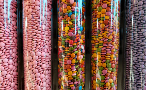 Colorful candies in transparent tubes displayed in a shop for customers to choose from over a busy weekend