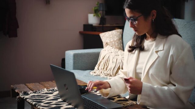 4K video of a happy young secretary celebrating after successfully completing an online purchase with her credit card. E-commerce, consumer satisfaction and digital lifestyle concept.
