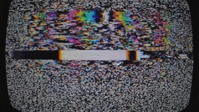 A television screen displays static with a white bar and multicolored patterns.