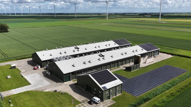 Aerial view of modern farm with solar panels and wind turbines