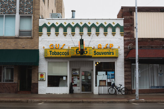 Front of Gus Asp souvenir and tobacco store with historic neon storefront in Escanaba, Michigan, January 2021