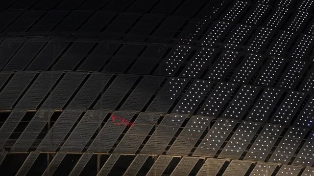 Nighttime illuminated grid panel facade with glowing dot matrix lighting effect