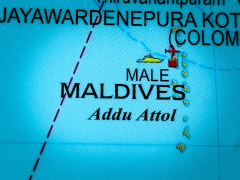 Closeup of a world map highlighting the maldives, male, and addu atoll, with a small airplane icon indicating a flight destination or travel route