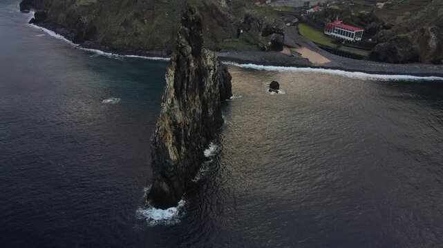 Breathtaking aerial view flying around the iconic volcanic sea stack of Ribeira da Janela on the north coast of Madeira Island, Portugal