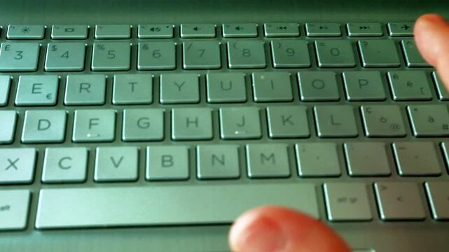 A man's hand types on a laptop keyboard. The video recalls several concepts such as remote working, connectivity and technology