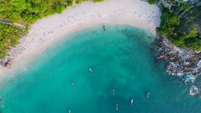 Overhead perspective reveals a serene beach cove in Phuket Thailand where dense jungle meets clear tropical sea