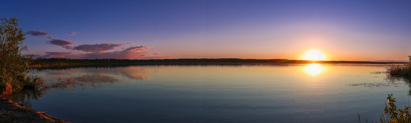 Fototapeta premium Wide panoramic view of a Northern Saskatchewan lake at sunset.