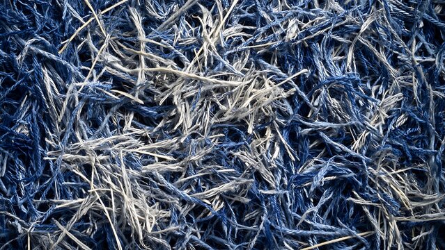 Abstract Background of Shredded Blue and Grey Denim Fibers Forming Dense Recycled Textile Pattern