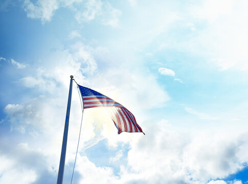 American Flag with glowing sun over sky