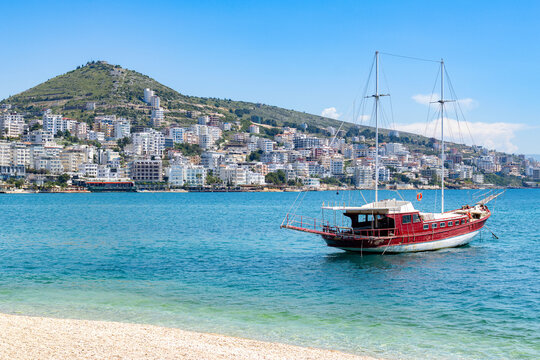 Beautiful beach with a boat on turquoise waters in European city.
