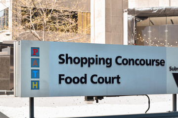 Naklejka premium PATH Shopping Concourse Food Court sign displayed on a downtown Toronto street, directing pedestrians to the underground PATH network and dining area, May 2026