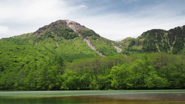 初夏の観光名所上高地の大正池と新緑の森と穂高連峰の風景