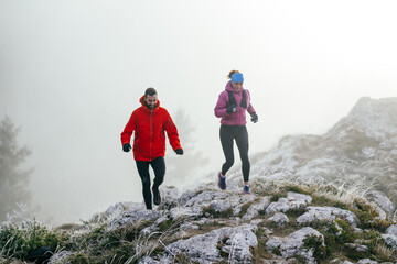 Obraz premium Trail running couple man and woman running on a mountain path