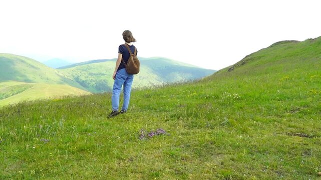 Female hiker enjoys quiet mountain panorama before continuing journey across breezy hillside. Reflects transitional moments in travel, reflective outdoor experiences, and unhurried exploration.