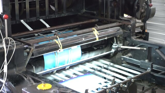 Old printing press machine with paper and ink in workshop