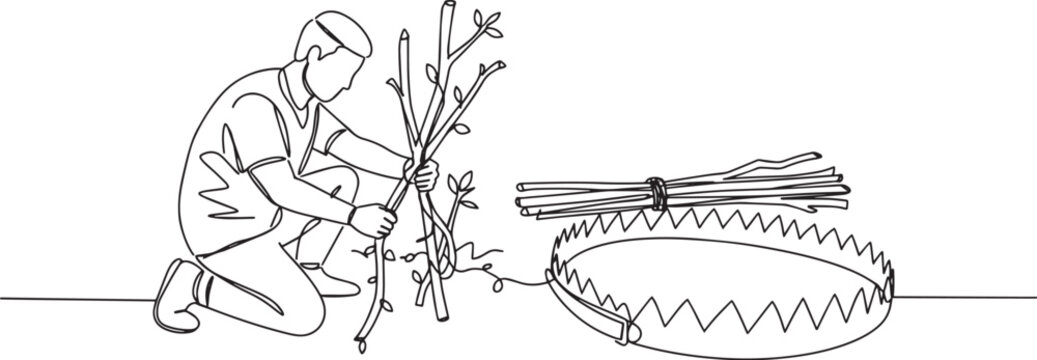 Man setting up a trap with sticks, focusing on the main subject.
