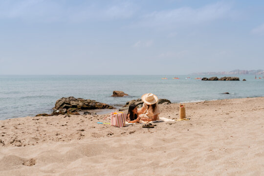 Woman enjoying time with her daughter at beach 