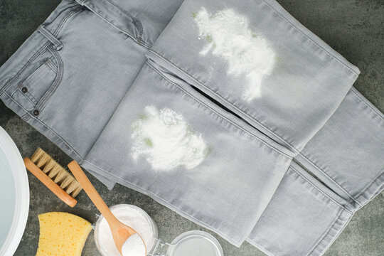Grey jeans sprinkled baking soda powder. Natural cleaning alternatives products for removing stains from clothes. Concept alternative and eco-friendly cleaning products. top view