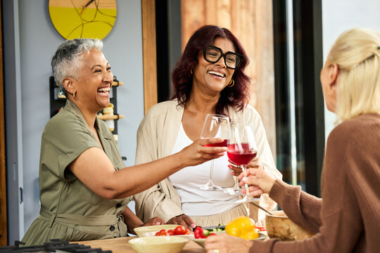 Women Share Drinks, toast and Smiles in a Kitchen