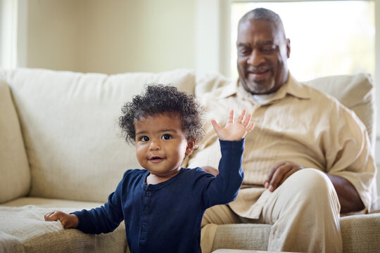 Baby Waves at Grandparent in Living Room During Daytime
