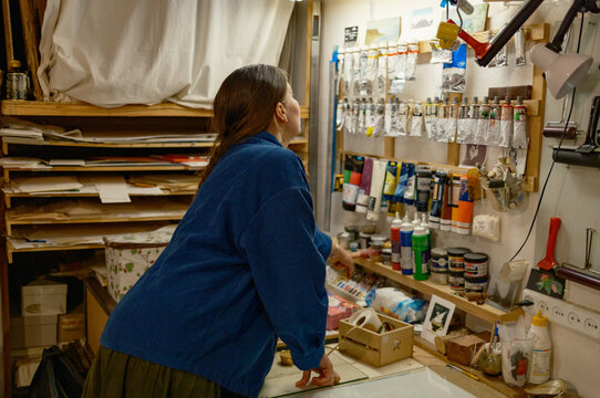 A female artist selects paints at a stand to create prints