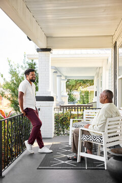 Father and son talking on Porch During Sunny Afternoon
