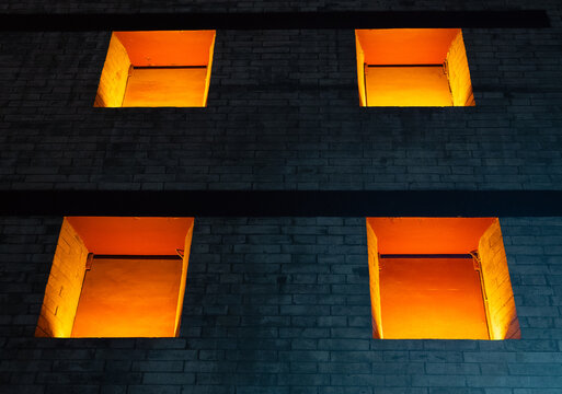 Illuminated windows pattern on stone wall