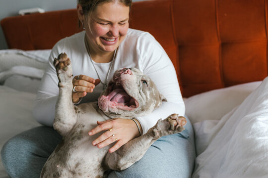 Joyful moment between woman and American bulldog at home