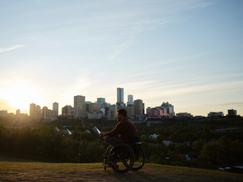 City skyline view from a hillside with a man in a wheelchair